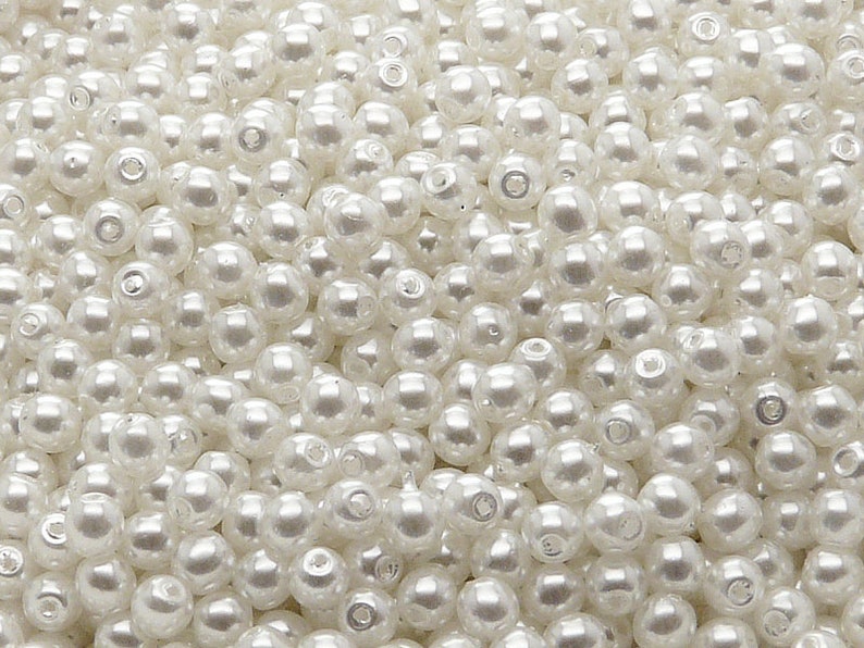 May include: A large quantity of white pearl beads. The beads are round and smooth, and they are perfect for making jewelry or other crafts.