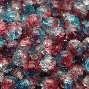 May include: A close-up shot of a collection of round, crackled glass beads. The beads are a mix of red, blue, and clear. These beads are likely for jewellery making or other craft projects.