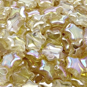 May include: A bulk bag of iridescent gold star-shaped glass beads. The beads are approximately 6mm in size and have a slightly irregular shape.