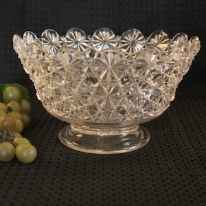 May include: A clear glass bowl with a scalloped rim and a cut glass design. The bowl is on a pedestal base.