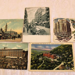 May include: A collection of vintage postcards featuring various cityscapes and buildings. The postcards are in black and white and sepia tones, and they show a variety of architectural styles. Some of the postcards have text on them, such as the name of the city or the date the postcard was sent.