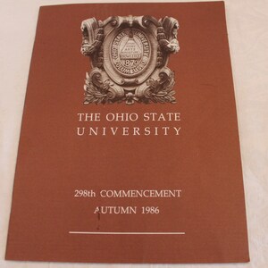 May include: A brown program cover for The Ohio State University's 298th Commencement, held in Autumn 1986. The cover features the university's seal with a crest and the words "The Ohio State University".