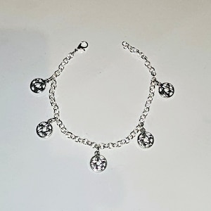 May include: A silver chain bracelet with five dangling charms. Each charm is a circular design with a star-shaped pattern.