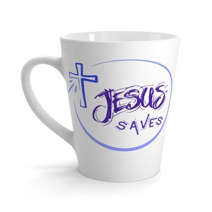 Może przedstawiać: Biały ceramiczny kubek do latte z zakrzywionym uchwytem. Kubek przedstawia niebieski krzyż i słowa "JESUS SAVES" w stylu ręcznym, zamknięte w niebieskim owalu.