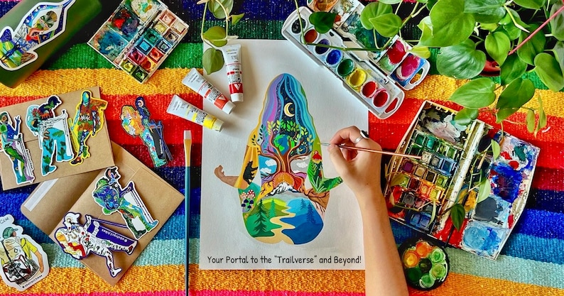May include: A person paints a colorful illustration of a person with a tree growing out of their head. The illustration is surrounded by a variety of nature scenes, including mountains, rivers, and forests. The text "Your Portal to the "Trailverse" and Beyond!" is written at the bottom of the illustration.