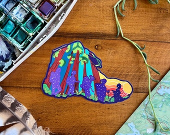 May include: A sticker featuring a group of people hiking through a forest with tall trees. The people are silhouetted in purple and blue, with stars scattered on their bodies. The background is a vibrant blue with green foliage and a sunset in the distance. The sticker is on a wooden surface with a watercolor palette and a feather.