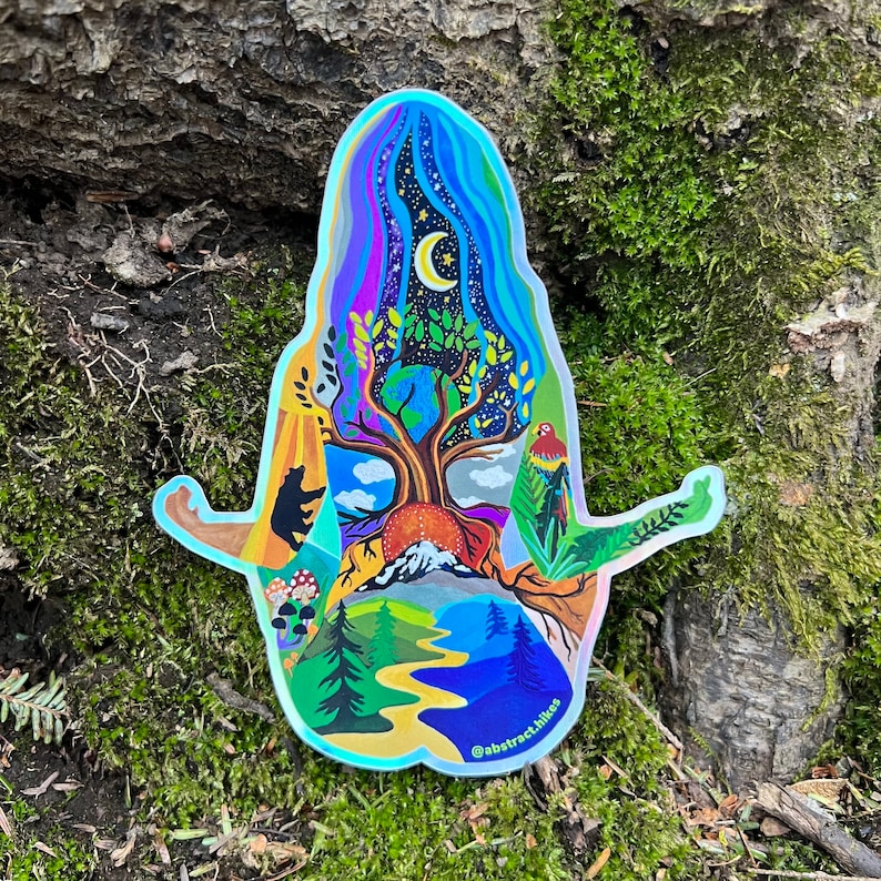 May include: A holographic sticker featuring a colorful illustration of a person meditating with a tree growing from their chest. The tree has a crescent moon in the sky above it and a variety of nature elements surrounding it, including mountains, a river, and a bird. The sticker has the text "@abstract.hikes" at the bottom.