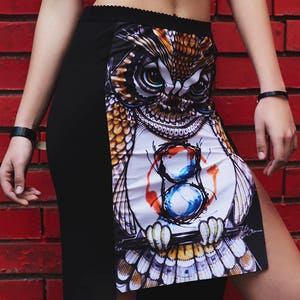 Peut inclure: Une jupe noire avec un imprim&eacute; de hibou blanc. Le hibou tient un pinceau et une palette de peinture. La jupe a une fente sur le c&ocirc;t&eacute;.