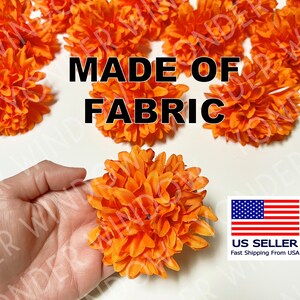 Op de afbeelding: Fel oranje stoffen bloemen, met de tekst "MADE OF FABRIC". Een hand houdt een van de bloemen vast. De afbeelding bevat een Amerikaanse vlag en de woorden "US Seller".
