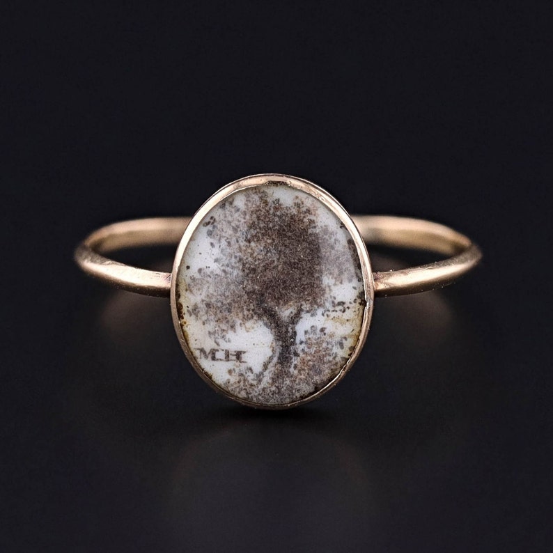 An antique Georgian era tree of life ring of macerated human hair with the initials MH.  This antique piece is in very good condition.  It would be perfect for any antique jewelry collector.