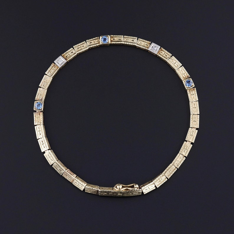 Our sapphire and diamond line bracelet with ornate links and gemstone accents.  The piece is 14k yellow gold with platinum near the diamonds.  Perfect for any Roaring Twenties jewelry collector.