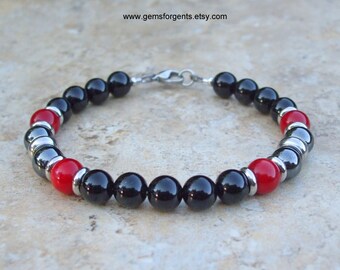 May include: Black, red, and silver beaded bracelet with a lobster clasp closure. The bracelet features black onyx, red coral, and hematite beads.