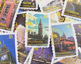 May include: A collection of colorful stamps with images of London landmarks, including Big Ben, a red double-decker bus, and a red telephone booth. The stamps have gold foil accents and the text "@LONDON HAVE A GOOD TRIP".