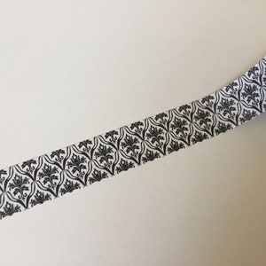 May include: Black and white patterned washi tape with a damask design.