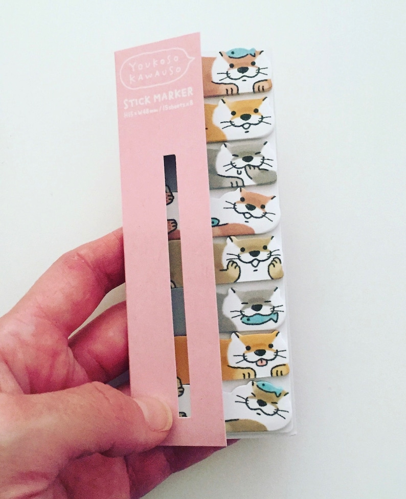 K&ouml;nnte beinhalten: Eine rosa und wei&szlig;e Packung Youkoso Kawaiuso Stick Marker mit einem Design einer Cartoon-Otter mit einem Fisch auf dem Kopf. Die Verpackung hat ein transparentes Fenster, das die bunten Marker zeigt.