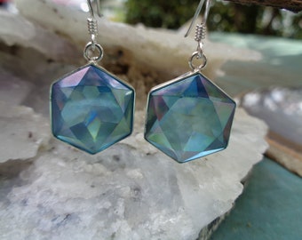 May include: A pair of silver earrings with iridescent blue hexagonal gemstones. The earrings have a simple design and are perfect for everyday wear.