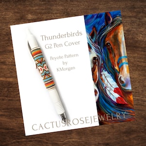 Puede incluir: Un bolígrafo blanco con una cubierta de cuentas que presenta un patrón geométrico colorido. El bolígrafo está sobre una tarjeta blanca con el texto "Thunderbirds G2 Pen Cover Peyote Pattern by KMorgan CACTUSROSEJEWELRY". La tarjeta está delante de una pintura de dos caballos con plumas azules, rojas y blancas.