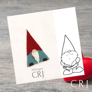 Puede incluir: Un adorno de gnomo de cuentas con un gorro rojo, pantalones azules y barba blanca. El gnomo está en una tarjeta blanca con el texto "KMorgan CRJ".