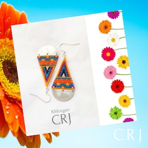 May include: A pair of colorful beaded teardrop earrings with silver accents. The earrings feature a geometric pattern in shades of orange, blue, pink, and white. The earrings are labeled "KMorgan CRJ".