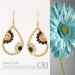 May include: Gold teardrop earrings with brown, gold, and green beads. The earrings are shaped like a teardrop and have a small flower design in the center. The earrings are called "Daisy Field Teardrop Earrings by KMorgan".