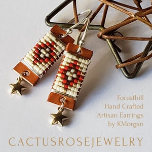 May include: Hand-crafted artisan earrings with a rectangular design. The earrings feature a tan leather base, beaded pattern in white, red, and brown, and a gold star charm. The text "Cactus Rose Jewelry" is at the bottom.