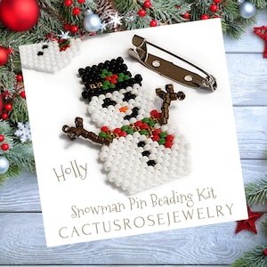 May include: A snowman pin beading kit with a white beaded snowman, black hat, and orange carrot nose. The kit includes a pin backing and the text "Holly" and "CACTUSROSEJEWELRY".