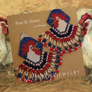 May include: A pair of beaded earrings featuring a rooster design in red, white, and blue. The earrings have a geometric shape with beaded fringe. The text "Rise & Shine" and "Cactus Rose Jewelry" are visible.