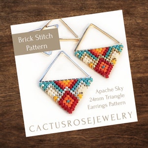 May include: A pair of triangle-shaped earrings with a beaded design in red, orange, yellow, white, and teal. The earrings are 24mm in size and are made using a brick stitch pattern. The text "Apache Sky 24mm Triangle Earrings Pattern" and "Cactusrosejewelry" is printed on the card.