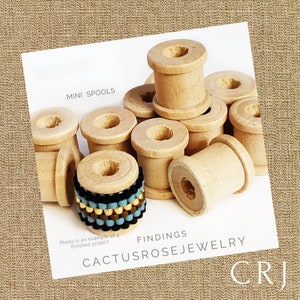 May include: A pile of small wooden spools, some with a hole in the center, and one spool with a beaded ring around it. The text "MINI SPOOLS" is at the top of the image, and the text "FINDINGS CACTUSROSEJEWELRY CRJ" is at the bottom of the image.