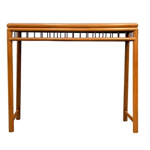 Può includere: Un tavolino da console in legno con un design a doghe sulla parte superiore e una cornice rettangolare semplice. Il tavolo è realizzato in legno marrone chiaro e ha una finitura naturale.