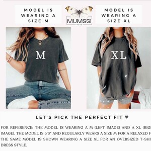 May include: Two women's t-shirts in different sizes, M and XL, are displayed. The shirts are dark gray and have the size printed in white. The text "LET'S PICK THE PERFECT FIT" is also visible.