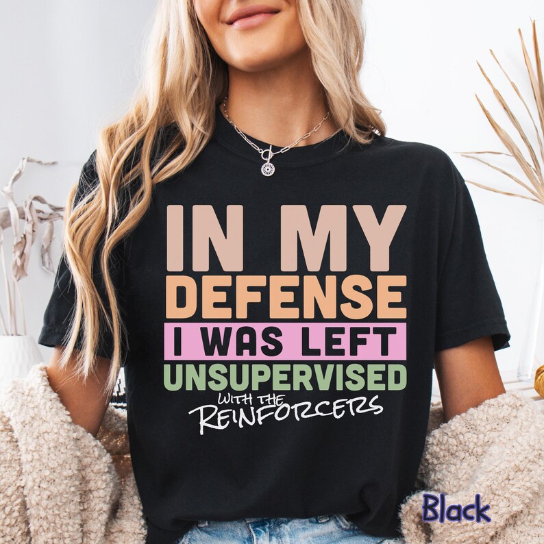 May include: Black t-shirt with the text "IN MY DEFENSE I WAS LEFT UNSUPERVISED WITH THE REINFORCERS" in various colours. The word "Black" is printed at the bottom right of the shirt.