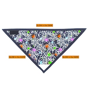 May include: Black bandana with a white spiderweb pattern and colorful spiders. The bandana glows in the dark. "GLOW in the DARK" is written on the bandana.