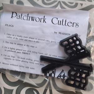 May include: A set of black plastic patchwork cutters for making flag shapes. The packaging reads "Patchwork Cutters" and "FLAGS". Includes two cutters and instructions for use.