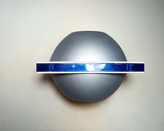 May include: A silver-colored, round, dome-shaped object with a blue, horizontal band around the middle.