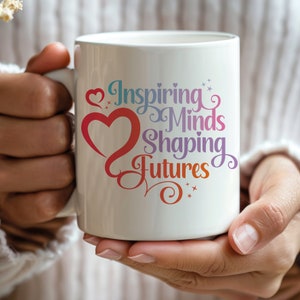 May include: White ceramic coffee mug with a colorful design that says "Inspiring Minds Shaping Futures" with a red heart and stars.