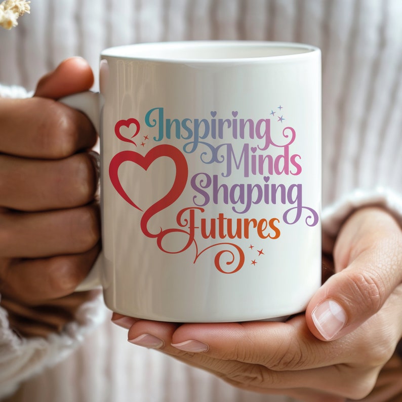 May include: White ceramic coffee mug with a colorful design that says "Inspiring Minds Shaping Futures" with a red heart and stars.