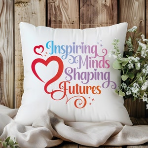 May include: White throw pillow with a colorful graphic that says "Inspiring Minds Shaping Futures" with a heart design.