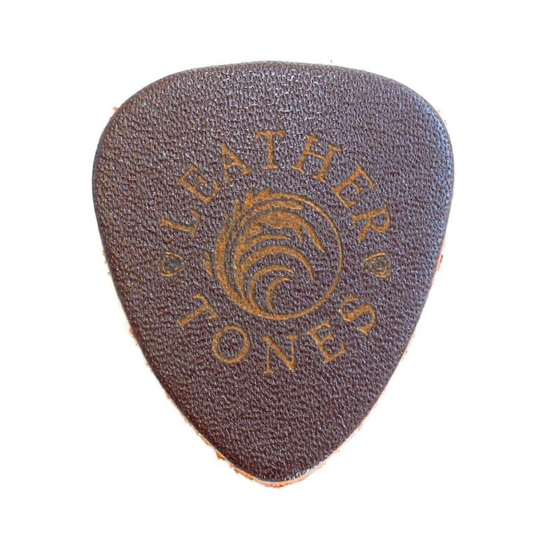 May include: A brown leather guitar pick with the text "Leather Tones" and a stylized wave design in gold.