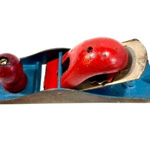 May include: A white ceramic mug with a black handle and the text "But First, Coffee" in a black, handwritten-style font. The mug is on a white surface.