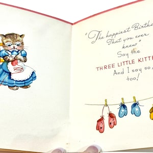 May include: Vintage birthday card featuring a cartoon cat wearing glasses and a blue dress, knitting with red yarn. The card includes the text "The happiest Birthday That you ever knew" and "Say the THREE LITTLE KITTENS".
