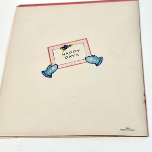 May include: A vintage greeting card with a cream-colored background and a pink border. The card features a rectangular frame with the words "HAPPY DAYS" and two blue mitten illustrations. The bottom right corner reads "MADE IN U.S.A."