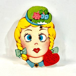 May include: Vintage Valentine's Day card featuring a cartoon girl with blonde braids, blue eyes, and a green hat adorned with flowers. The card includes a red heart with the text "Don't give me the shut-eye, My Valentine."