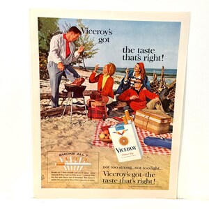 May include: A vintage advertisement for Viceroy cigarettes featuring a beach picnic scene with three people, a grill, and a picnic basket. The text reads Viceroy's got the taste that's right! and includes a pack of Viceroy Filter Tip cigarettes.