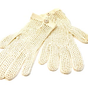 May include: A pair of off-white crochet gloves featuring an openwork mesh pattern throughout the hand and fingers. Each glove includes a solid crochet cuff with a single small, round, matching off-white button detail at the wrist area.