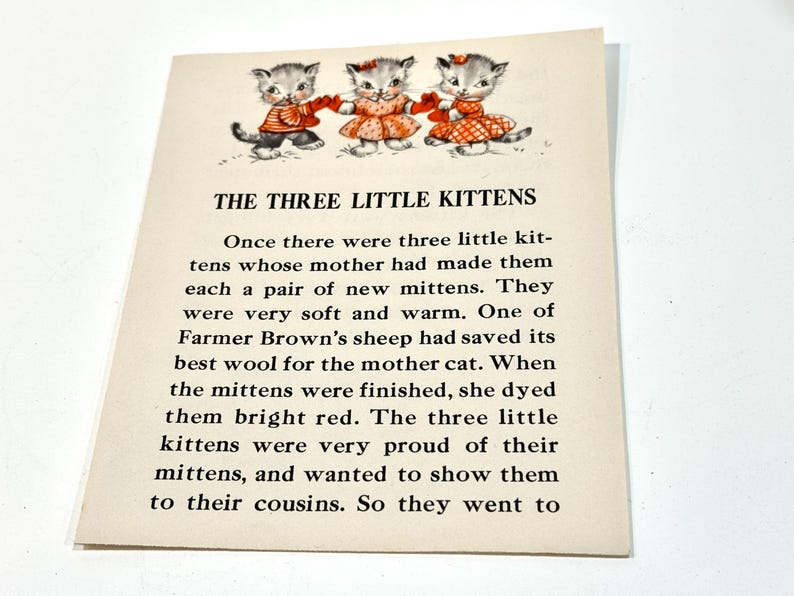 May include: Vintage illustration featuring three kittens wearing red mittens and dresses. The text reads "THE THREE LITTLE KITTENS" and tells a story about the kittens and their mittens. The image is on a cream-colored paper.