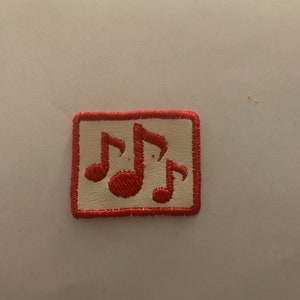 May include: Embroidered patch with three red musical notes on a cream background. The patch has a red border and is rectangular. Ideal for adding to clothing or accessories. The patch measures approximately 5 cm x 4 cm.