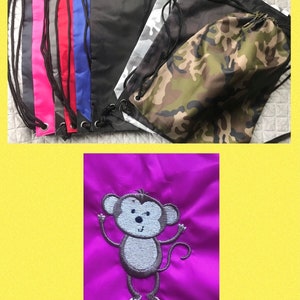 May include: A collection of drawstring bags in various colours and patterns, including black, grey, red, blue, camouflage, and white. The bags are made of a lightweight fabric and have a drawstring closure.
