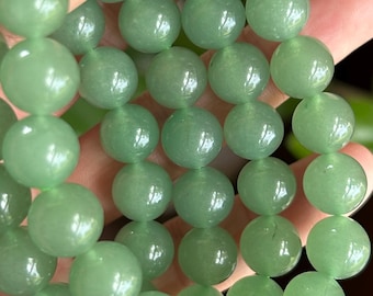May include: A strand of smooth, round, light green gemstone beads. Each bead features a polished, semi-translucent finish with subtle natural variations in color and texture, strung together to form a continuous circular jewelry piece.