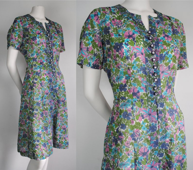 May include: A vintage floral print dress with a short sleeve, a v-neck, and a button-up front. The dress is made of a lightweight fabric and has a fitted bodice and a flared skirt.